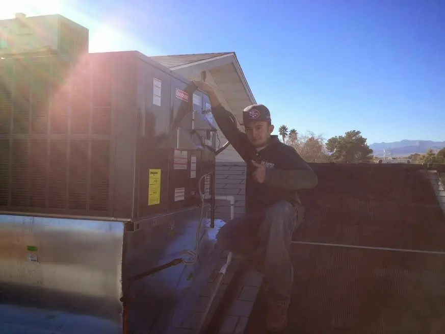 HVAC technician performing Boiler Repair on a rooftop unit in Paramount
