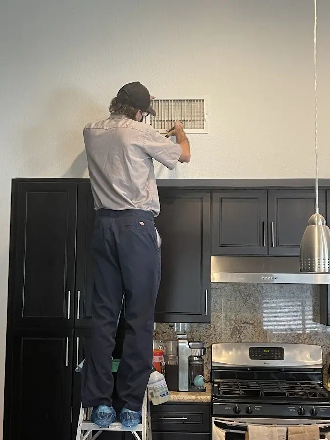 Technician inspecting an air vent during HVAC service in Paramount